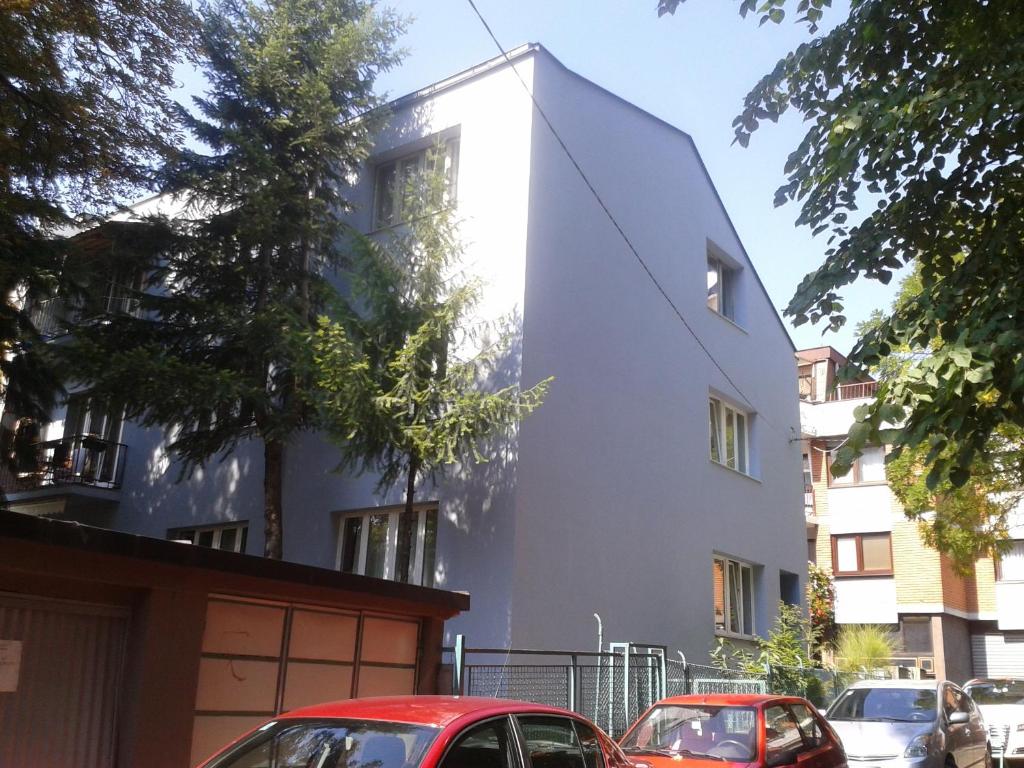 ein weißes Gebäude mit davor geparkt in der Unterkunft Downtown Gem Apartment in Sarajevo