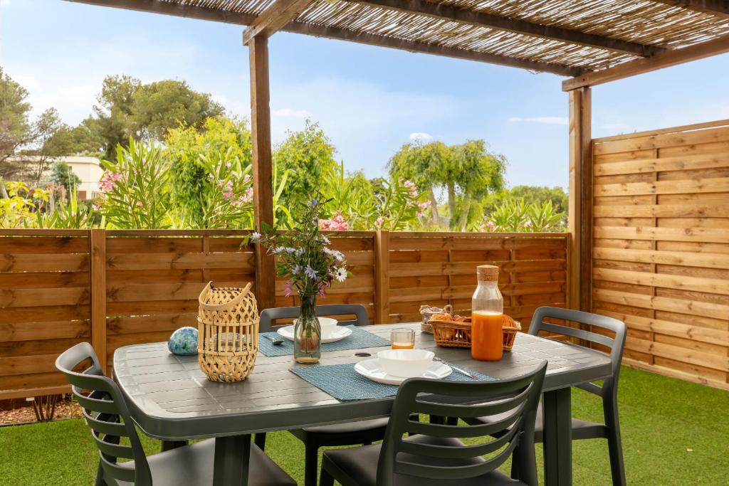 un tavolo e sedie su un patio di L'Estrellus, mobil-home climatisé au cœur du vignoble à quelques mètres de la mer a Hyères