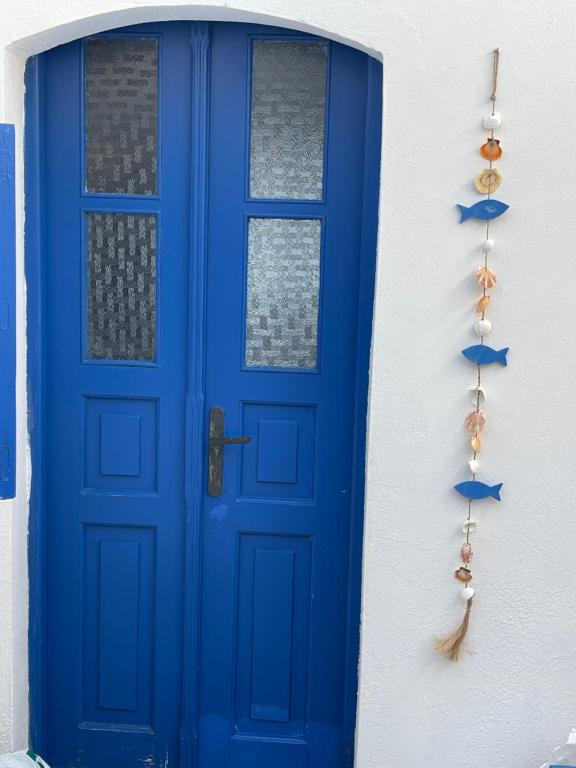 eine blaue Tür an einem Haus mit einer Tasse in der Unterkunft Emporios Traditional Sea View House in Emporeiós