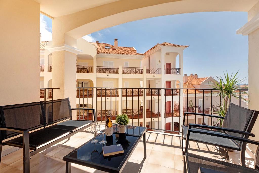 a balcony of a house with a table and chairs at El Palomar de Atteserg in Los Cristianos