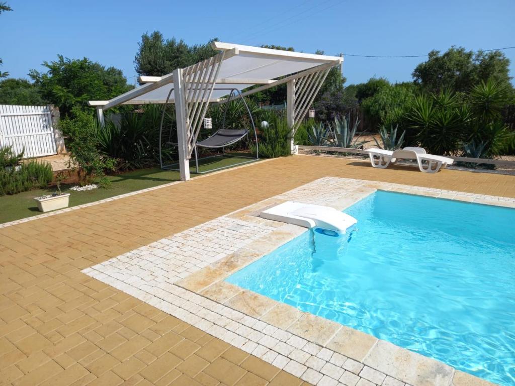 een zwembad met een pergola naast een huis bij Villa Ginevra - Camera & Piscina in Polignano a Mare