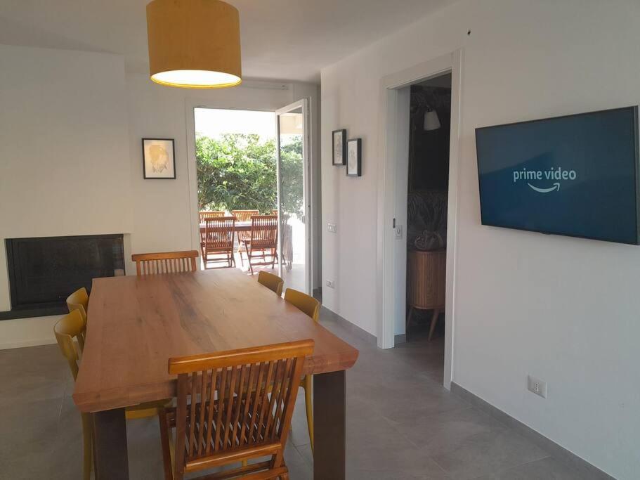 a dining room with a wooden table and chairs at Elegante monolocale Elmas Cagliari in Elmas