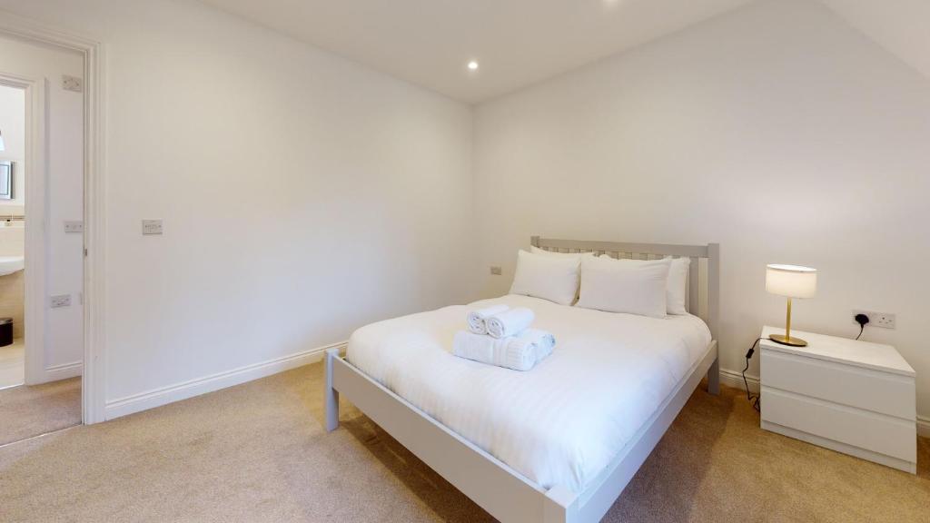 a bedroom with a white bed with a box on it at Carriage Crescent in Witney