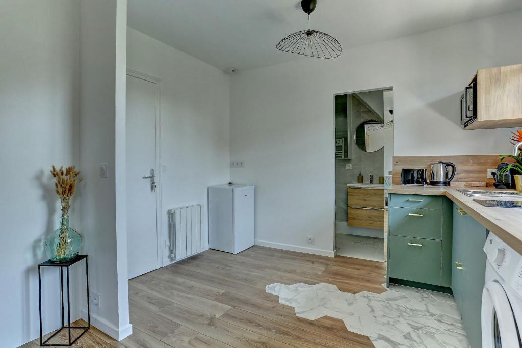 a kitchen with white walls and a green refrigerator at Le Normand- Bois d&#39;arcy in Bois-dʼArcy