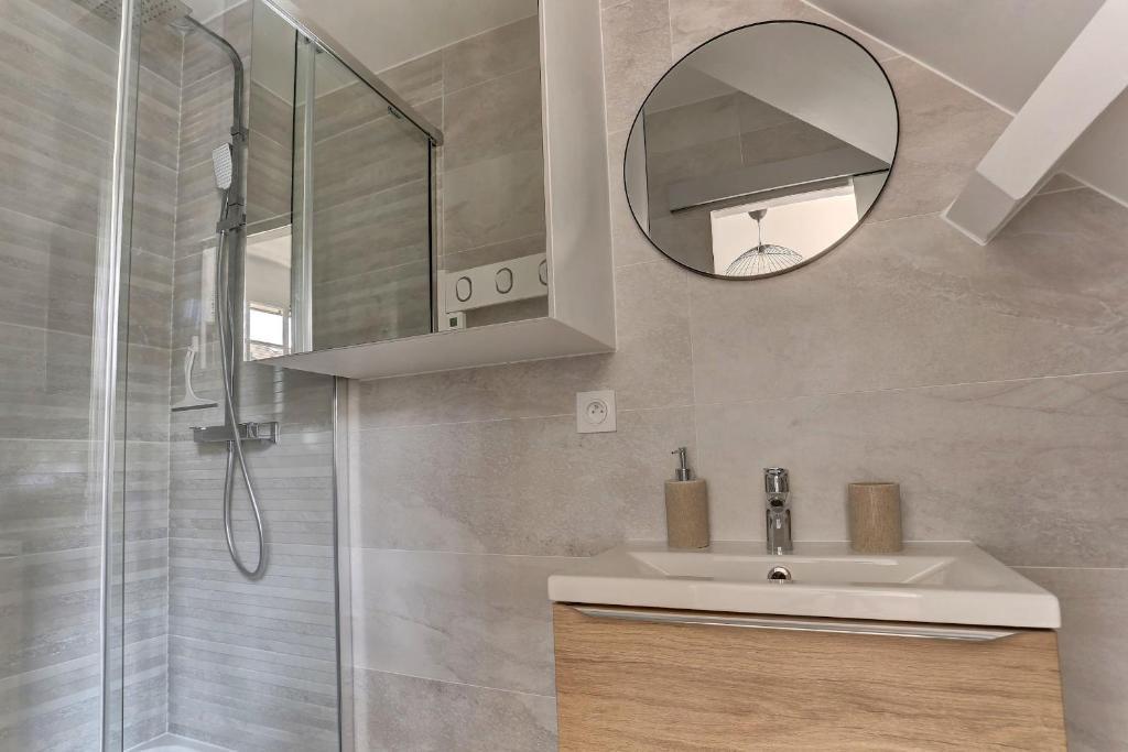 a bathroom with a sink and a mirror and a shower at Le Normand- Bois d&#39;arcy in Bois-dʼArcy