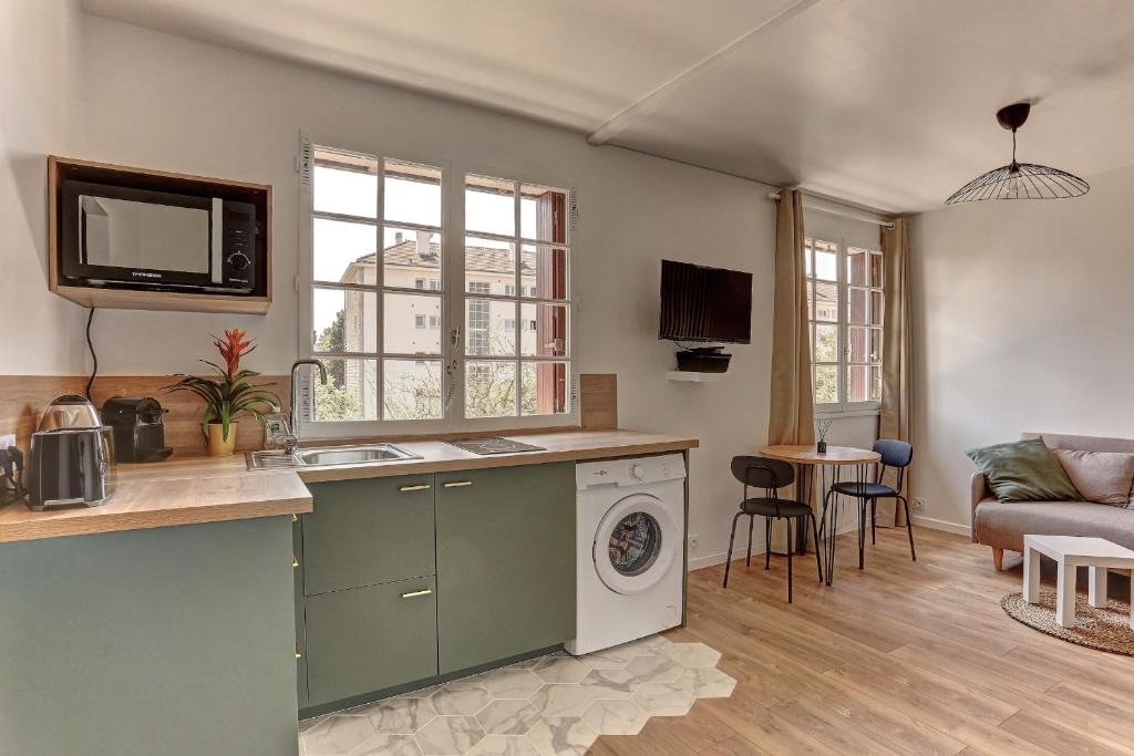 a kitchen with a washing machine and a living room at Le Normand- Bois d&#39;arcy in Bois-dʼArcy