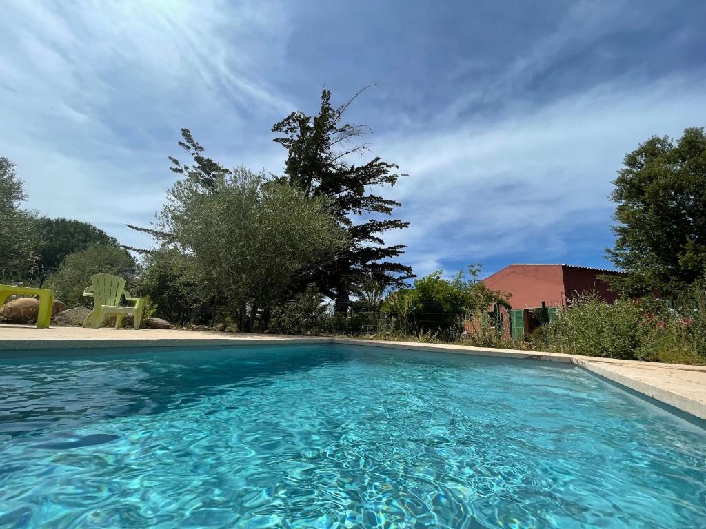 a swimming pool with blue water in a yard at Calenzana Trè - Appt avec piscine partagée in Calvi