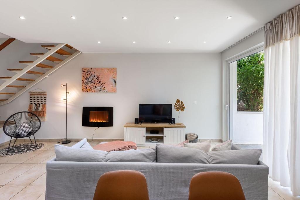 Secret Aktis by BluPine في أثينا: غرفة معيشة بها أريكة وجهاز تلفزيون