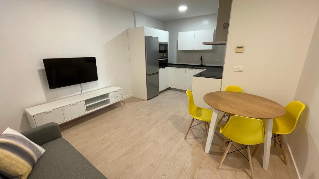 a kitchen and living room with a table and yellow chairs at Txoko Loft Moncayo in Tudela