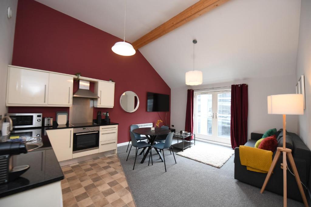 a kitchen and living room with a table and chairs at Harrogate Self Catering - Regent's Court Cherry Suite in Harrogate