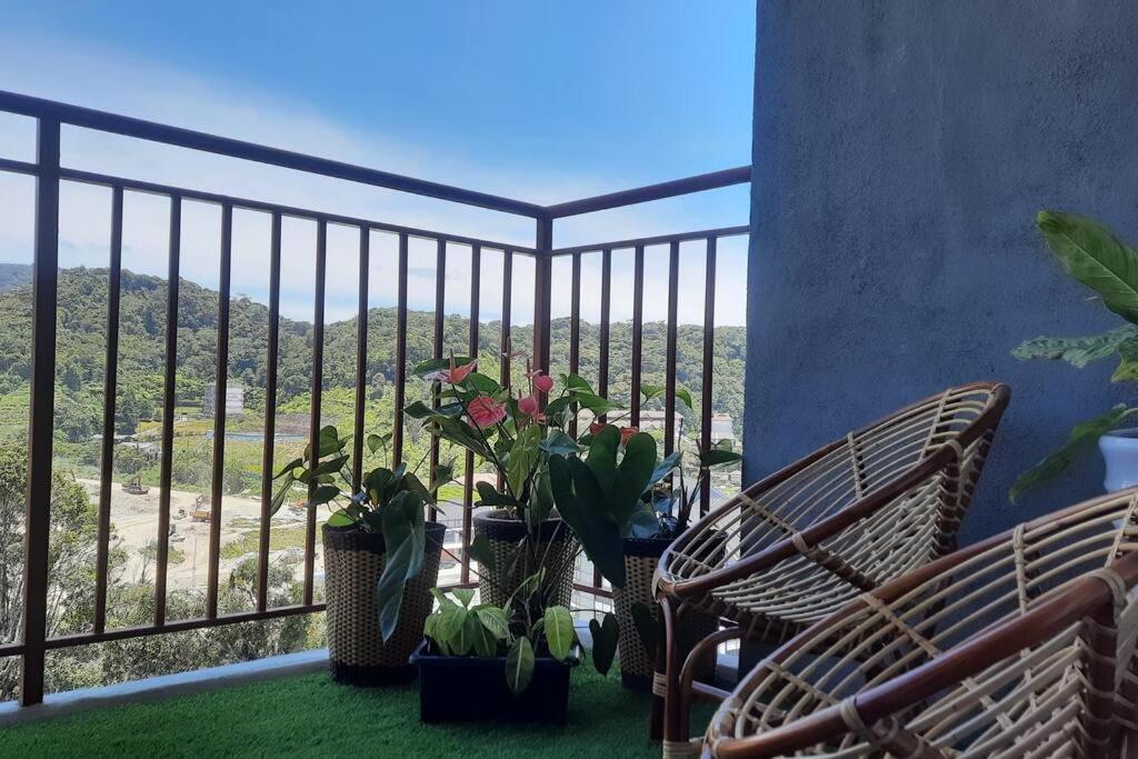 Un balcón con sillas y macetas y vistas. en Emerald Avenue Cozy 3R3B Apartment 830 en Brinchang