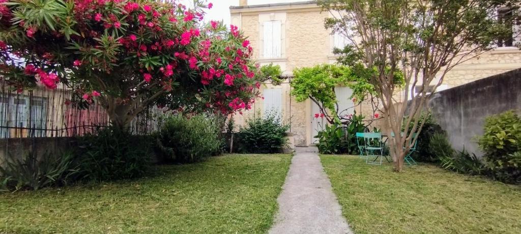 un jardin avec des fleurs roses et une clôture dans l'établissement Villa Jardin fleuri, à Avignon