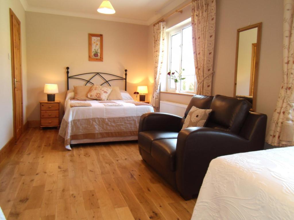 a bedroom with a bed and a chair at Seafield House B&B in Clifden