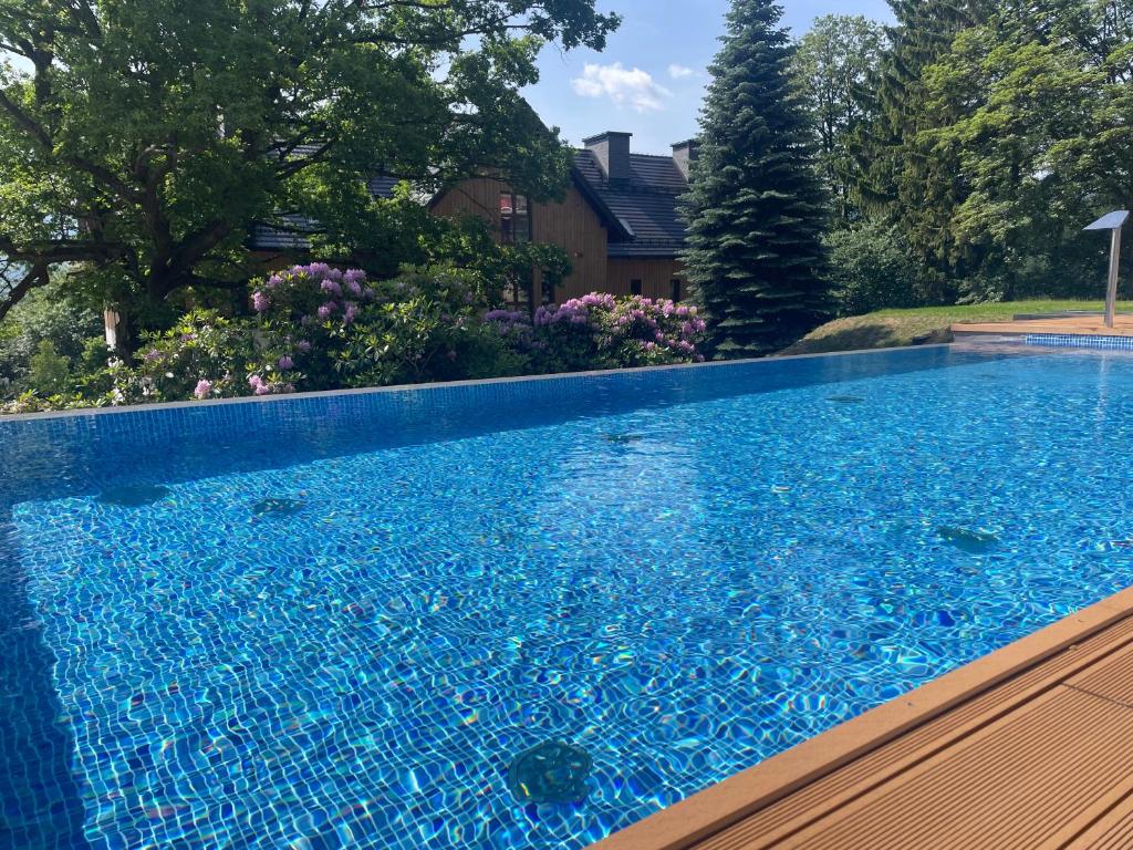 basen z niebieską wodą przed domem w obiekcie Apartament N&B w Szklarskiej Porębie