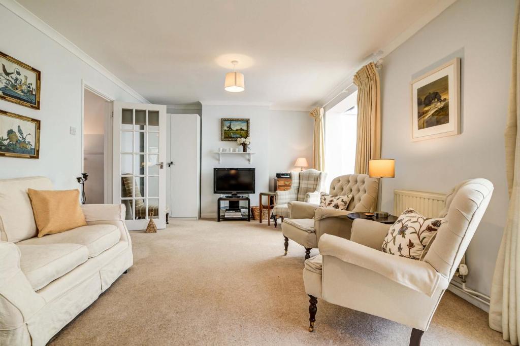 a living room with white furniture and a tv at High Trees Blenheim View in Woodstock