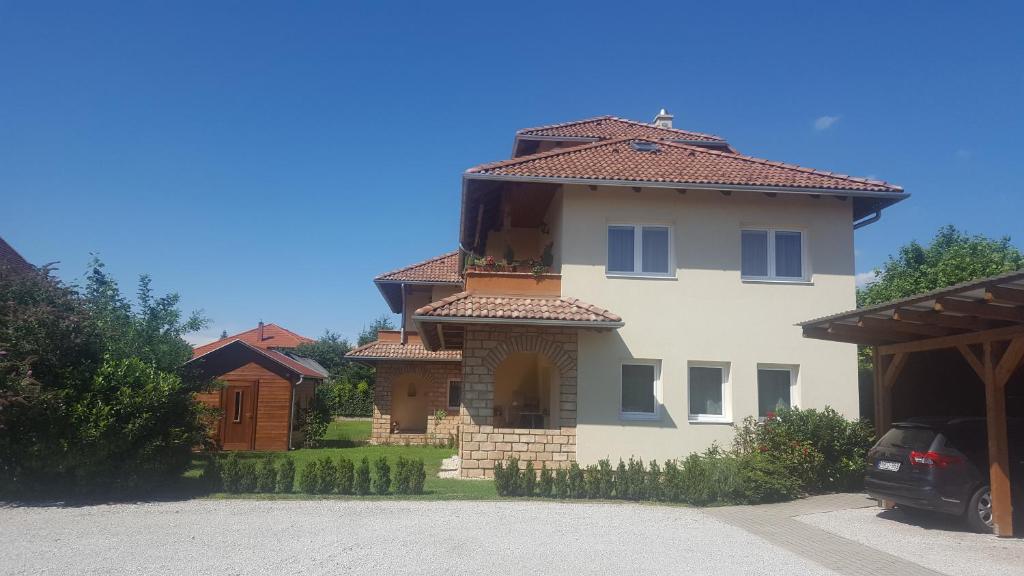 a large house with a car parked in front of it at Mediterrania Apartment in Keszthely