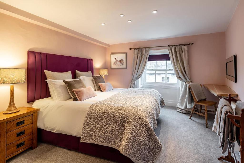 a bedroom with a large bed and a desk at Royal View Apartments in Kirkby Lonsdale