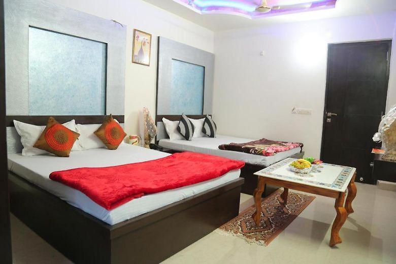 a bedroom with two beds and a table in it at Blossom residency By Dolphin 500 Mtr Taj mahal in Agra