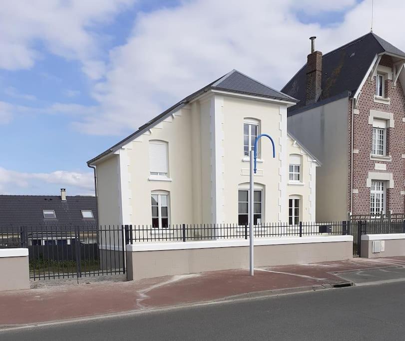 une maison blanche avec une clôture noire devant elle dans l'établissement Villa proche mer parking wifi, à Berck-sur-Mer