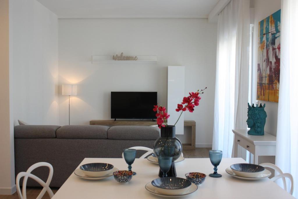 un soggiorno con tavolo e vaso con fiori di Strettomare-Business & travel apartment a Reggio di Calabria