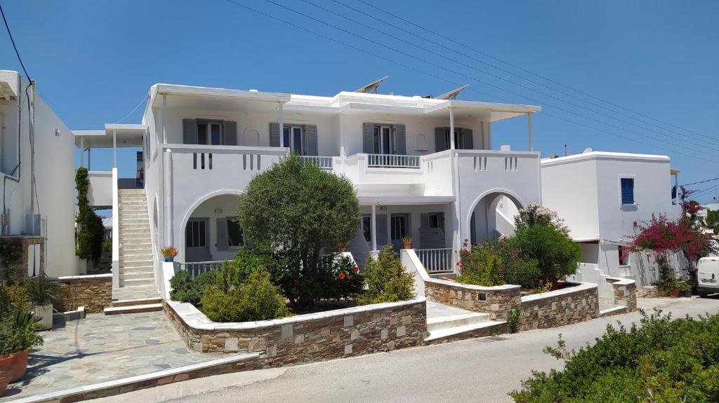 a white house with some plants in front of it at Marianos Apartments in Antiparos