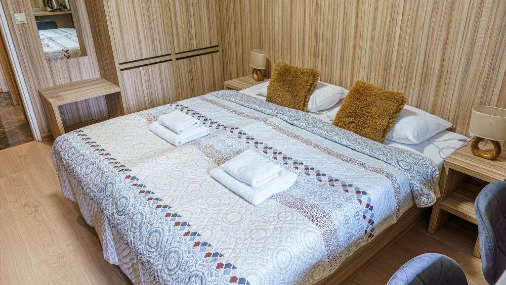 Hotel Garni في بوفاجسكا بيستريتسا: غرفة نوم بسرير كبير عليها مناشف
