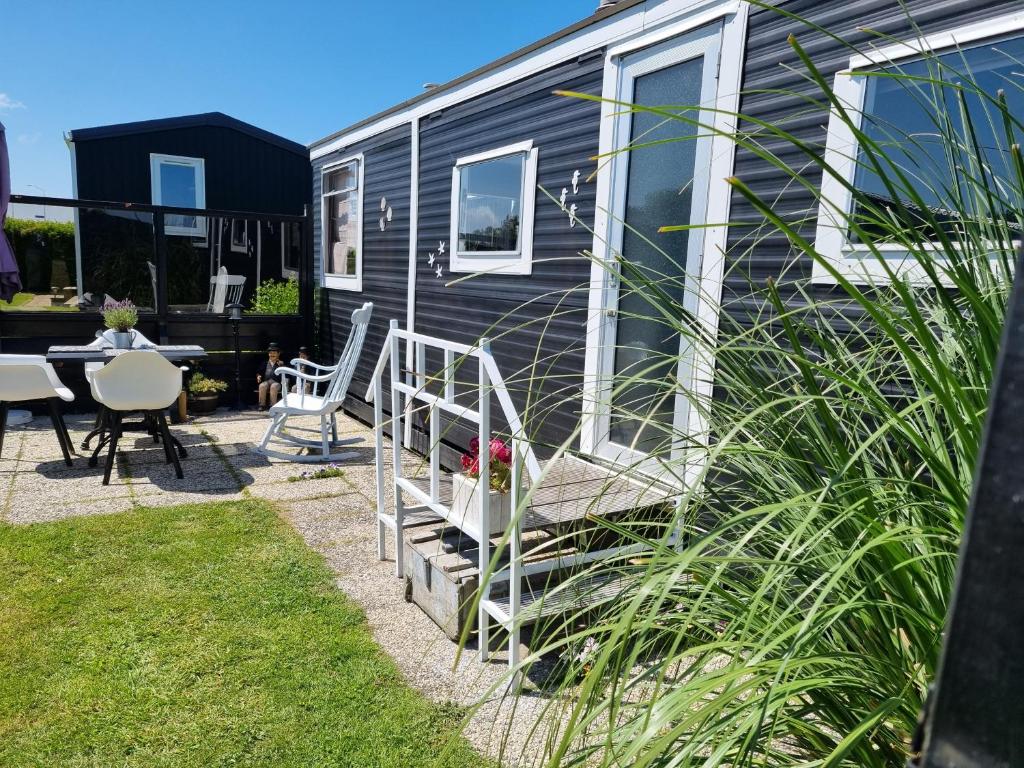 a house with a patio with a table and chairs at Meerblick Wattenmeer ,50m vom Meer,Strand 300m in Westerland