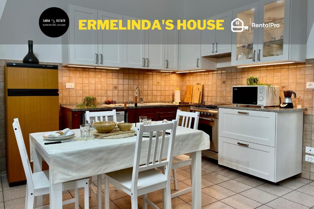 a kitchen with a white table with chairs and a microwave at [Menosio] La casa di Ermelinda - Relax in Arnasco