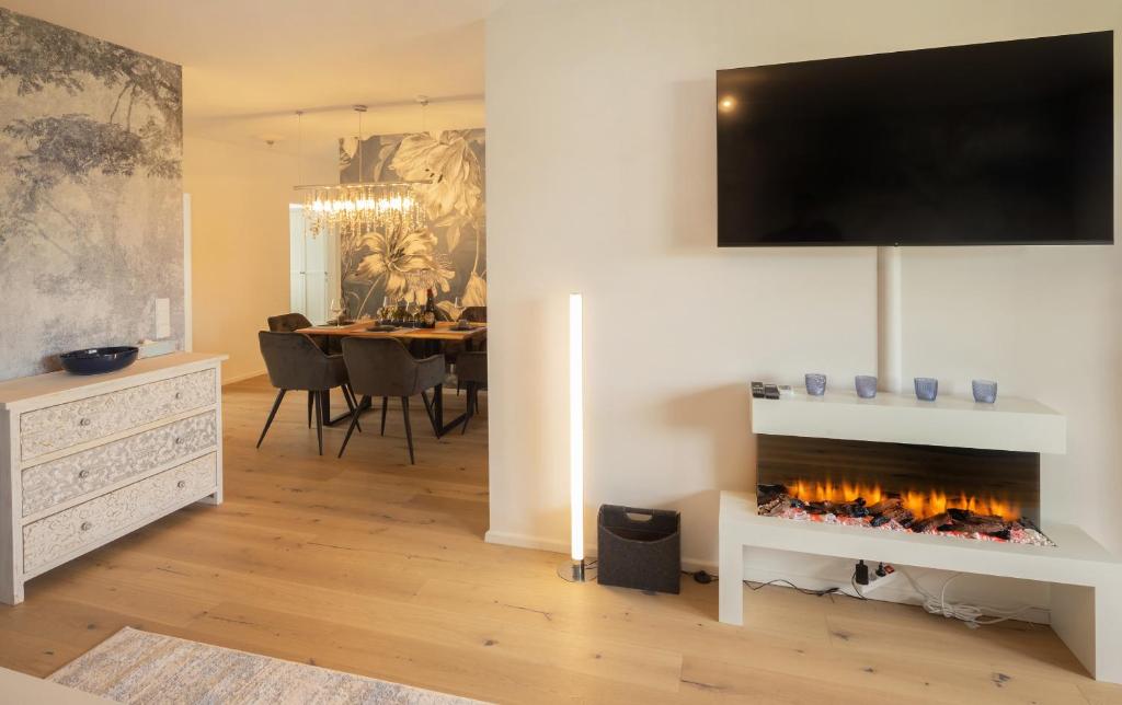 a living room with a fireplace with a tv above it at SweetHome - DAH02 - LUXUS PUR Apartment, Küche, TV in Dachau