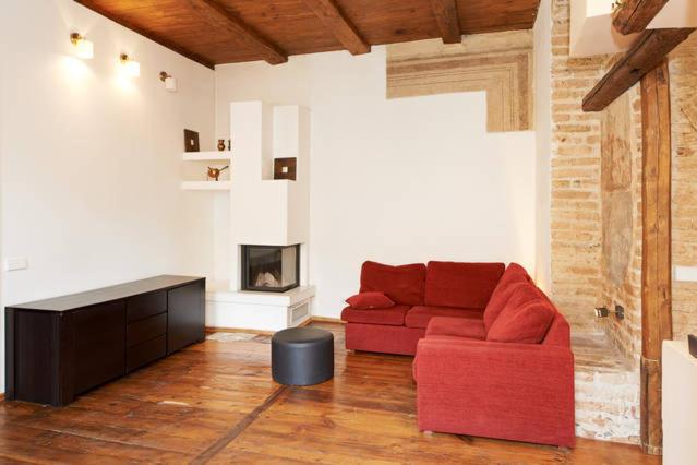 a living room with a red couch and a fireplace at Mykolo Apartments in Vilnius