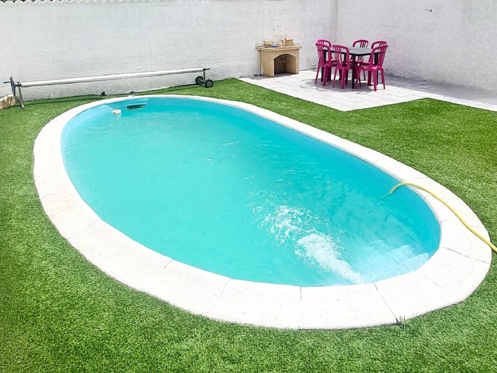 uma grande piscina num quintal com relva verde em Location maison avec piscine privée. em Agde