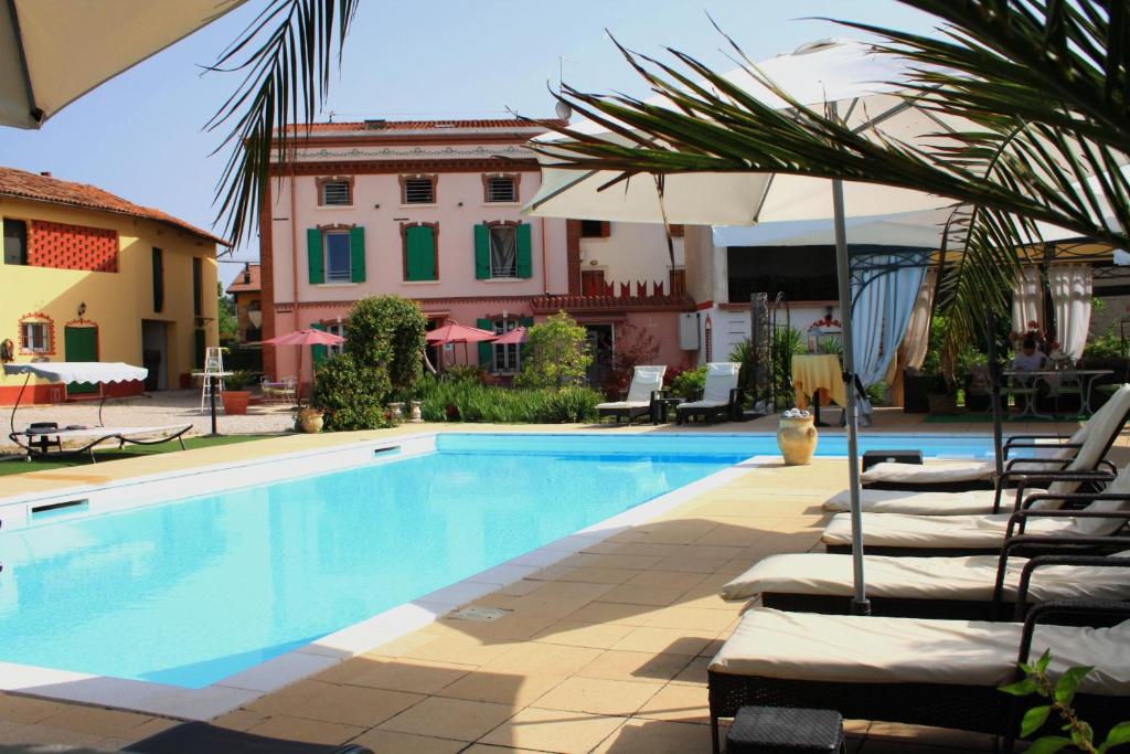 uma piscina com espreguiçadeiras e um guarda-sol em B&B Villa Rossella con piscina em Castelnuovo del Garda