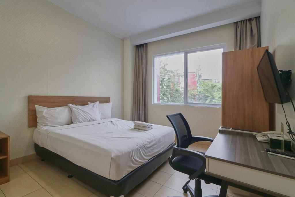 a hotel room with a bed and a desk and a computer at Aranis Hotel in Jakarta