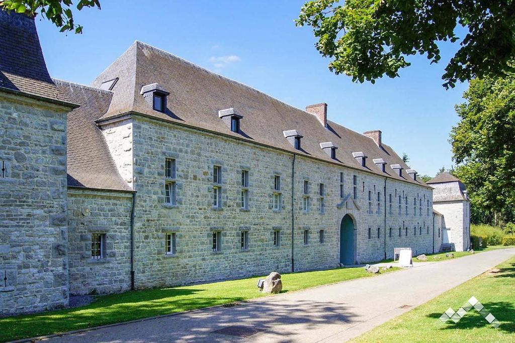 un grande edificio in pietra con tetto marrone di Dépendance du châteaux de Modave a Modave