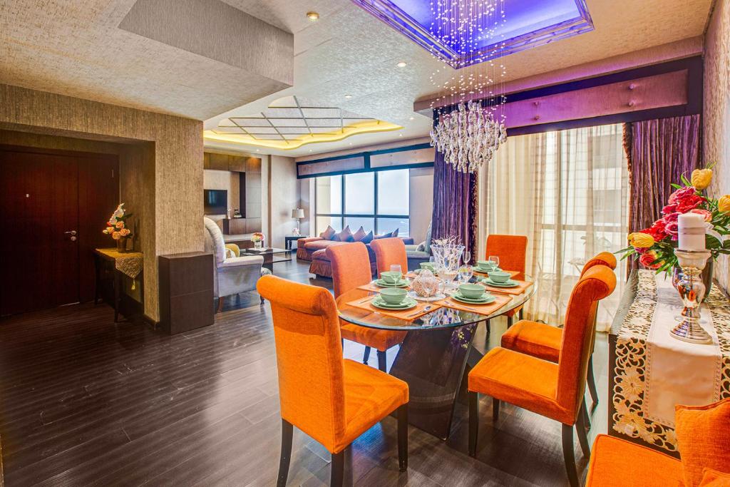 a dining room with a table and orange chairs at Amazing Sea View apartment in the JBR in Dubai