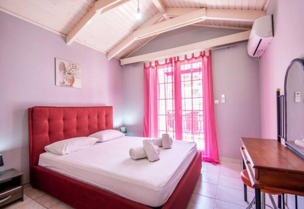 Schlafzimmer mit einem großen Bett mit einem roten Kopfteil in der Unterkunft Home Away Junior Suite. in Zakynthos