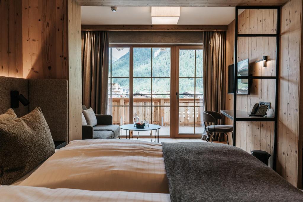 Una habitación de hotel con una cama y una ventana grande. en NOVA Moments Boutique Hotel, en Pertisau