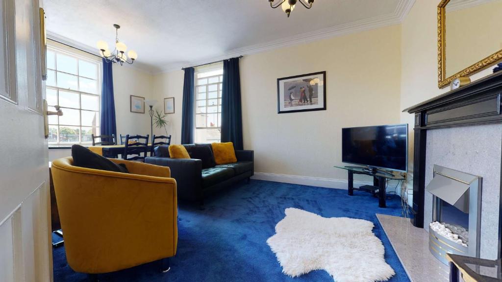 a living room with a couch and a fireplace at Portland Street Apartment in Leamington Spa