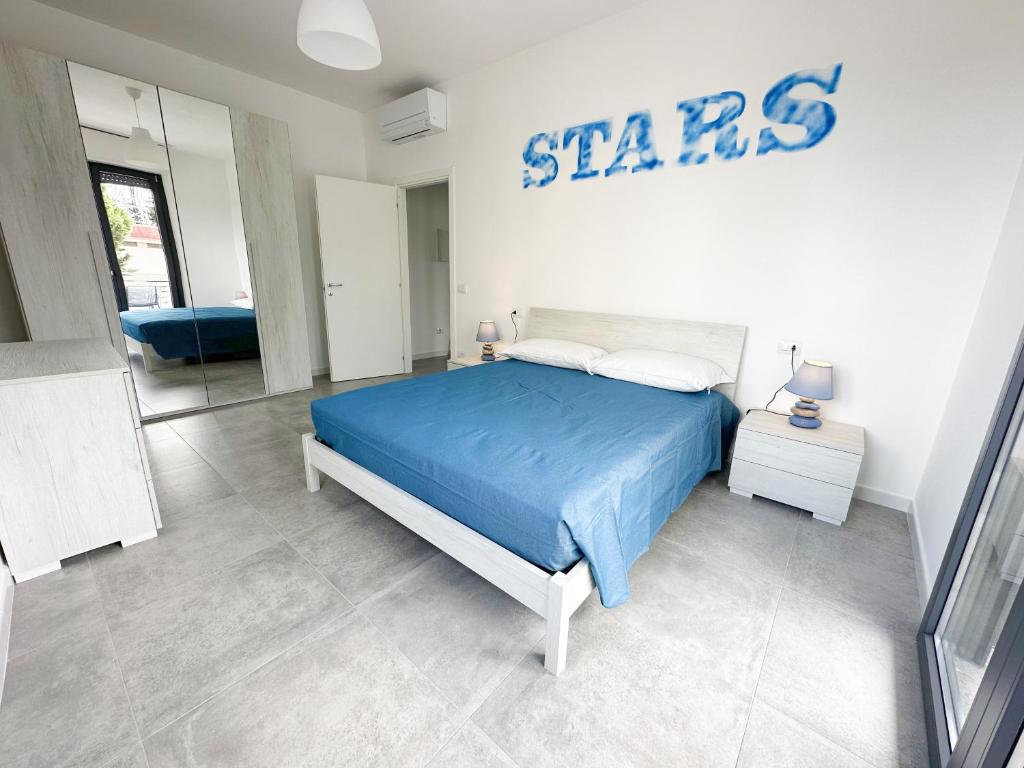 a bedroom with a blue bed and a sign on the wall at LUX apartments T in Follonica
