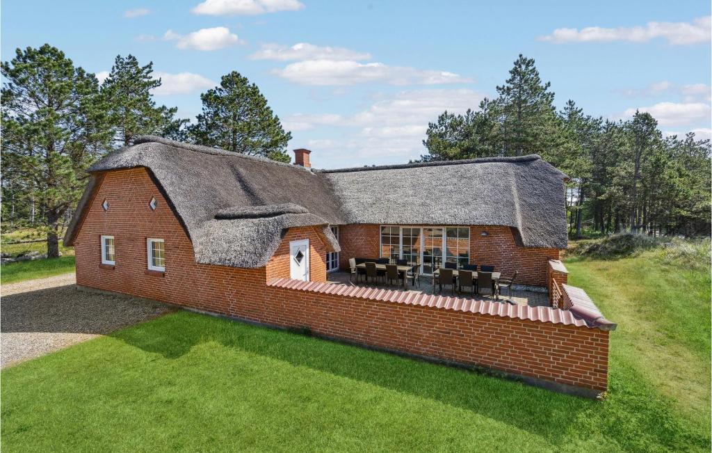 a large brick house with a thatched roof at Cozy Home In Rømø With Sauna in Kongsmark