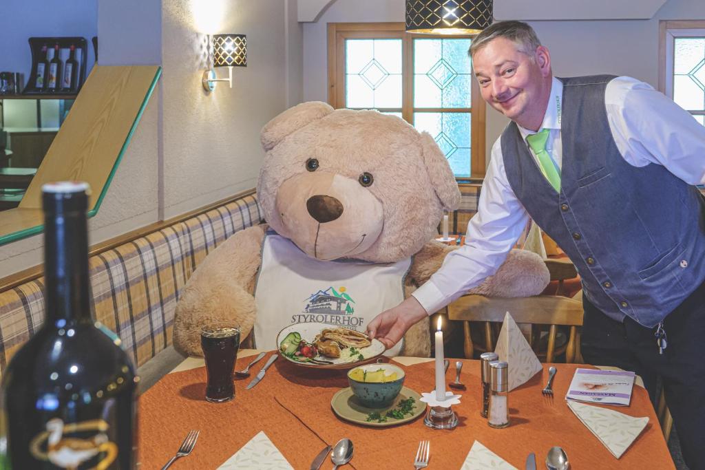 a man is standing next to a large teddy bear at Hotel Styrolerhof in Steeg