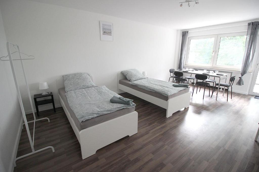 a bedroom with two beds and a table with chairs at Cozy Apartment in Remscheid in Radevormwald