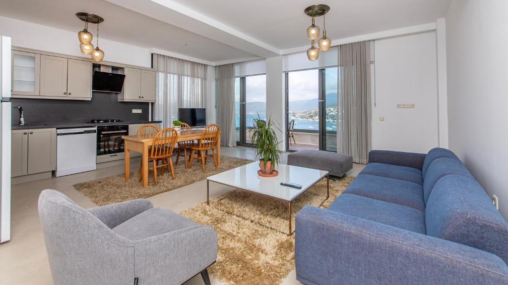 sala de estar con sofá azul y sillas y cocina en Villa House Sea View Türkbükü en Bodrum