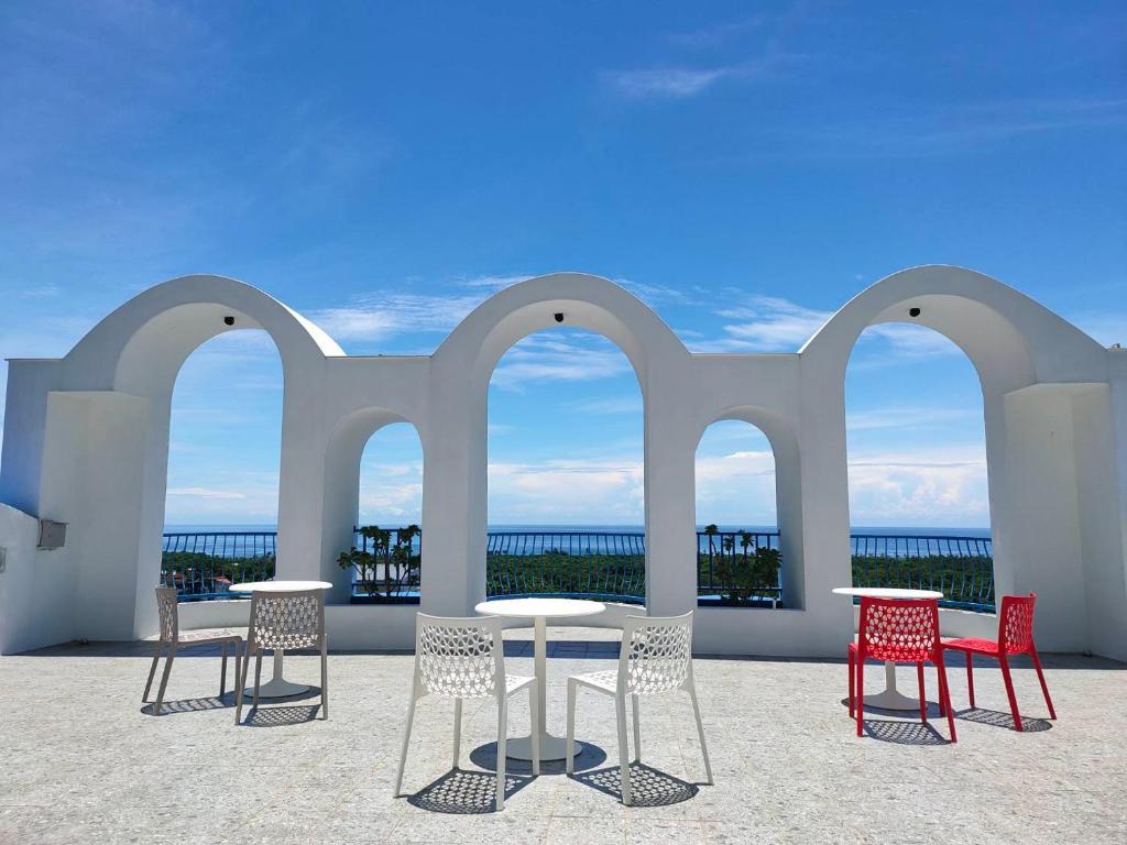 a patio with tables and chairs and the ocean at Taroko Tkijig Ocean B&B in Chongde