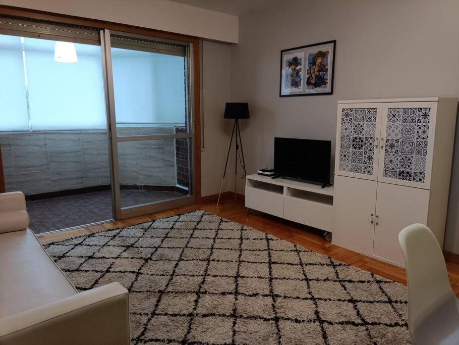 een woonkamer met een televisie en een bank bij Acogedor apartamento en Vigo in Vigo