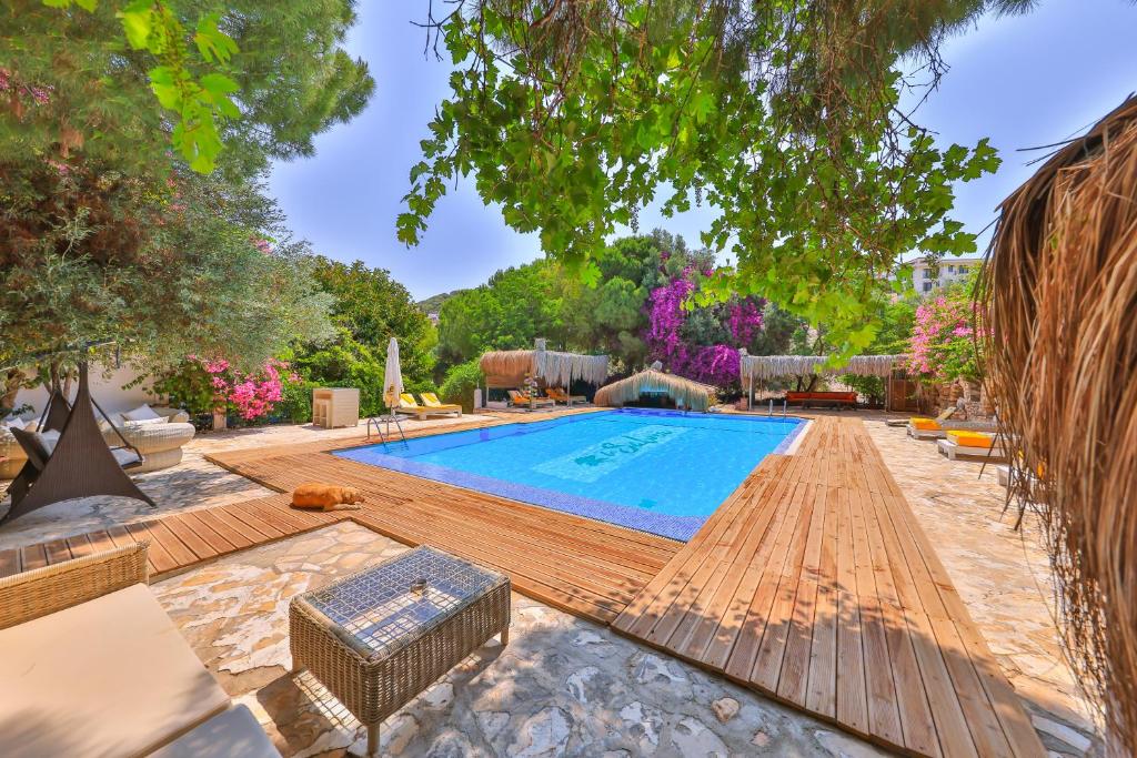 an outdoor swimming pool with a wooden deck and a swimming poolvisor at La Salvia Hotel Kas in Kaş