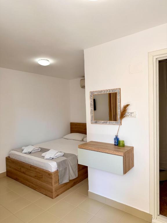 a bedroom with a bed and a mirror on the wall at Camere de inchiriat Sibel in Costinesti