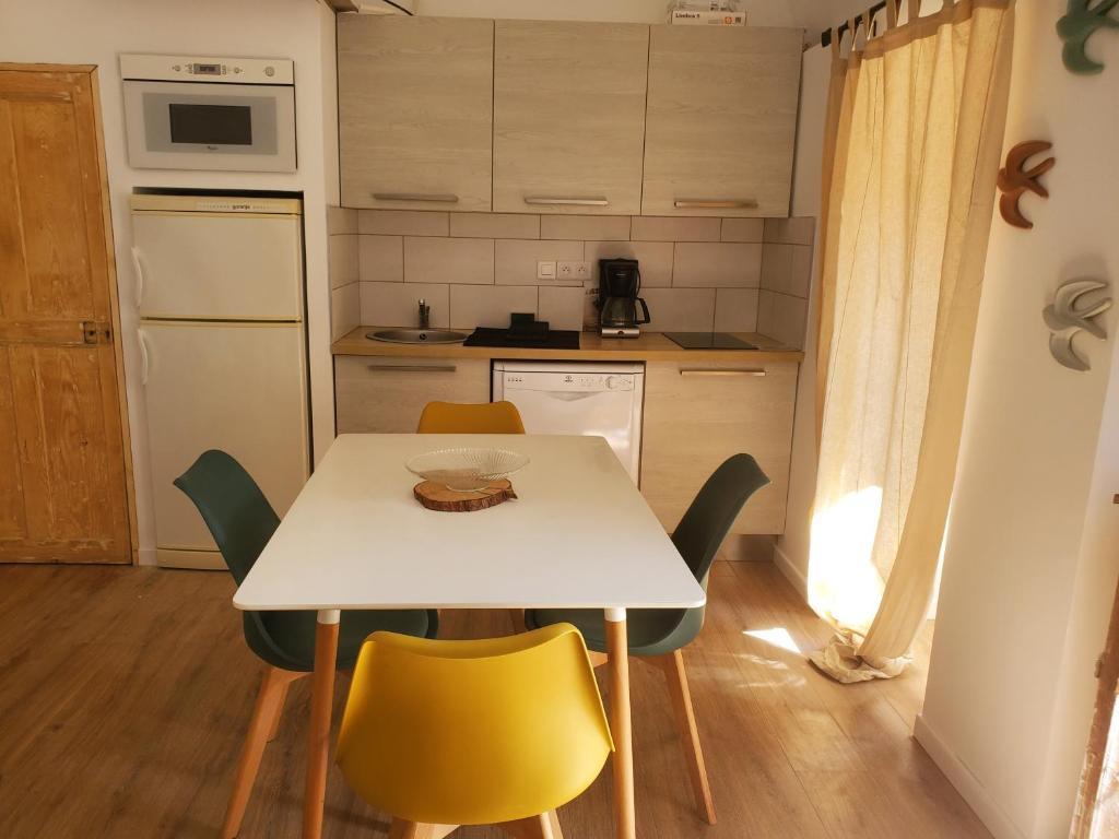 una pequeña cocina con mesa blanca y sillas en Corbara ,Pietralta, en Corbara