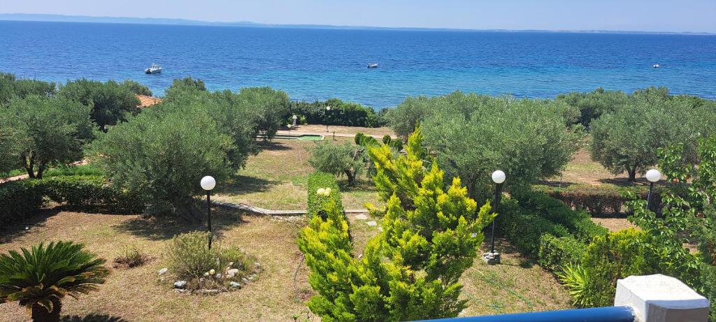 a view of a garden with trees and the ocean at Villa Gerakina in Gerakini