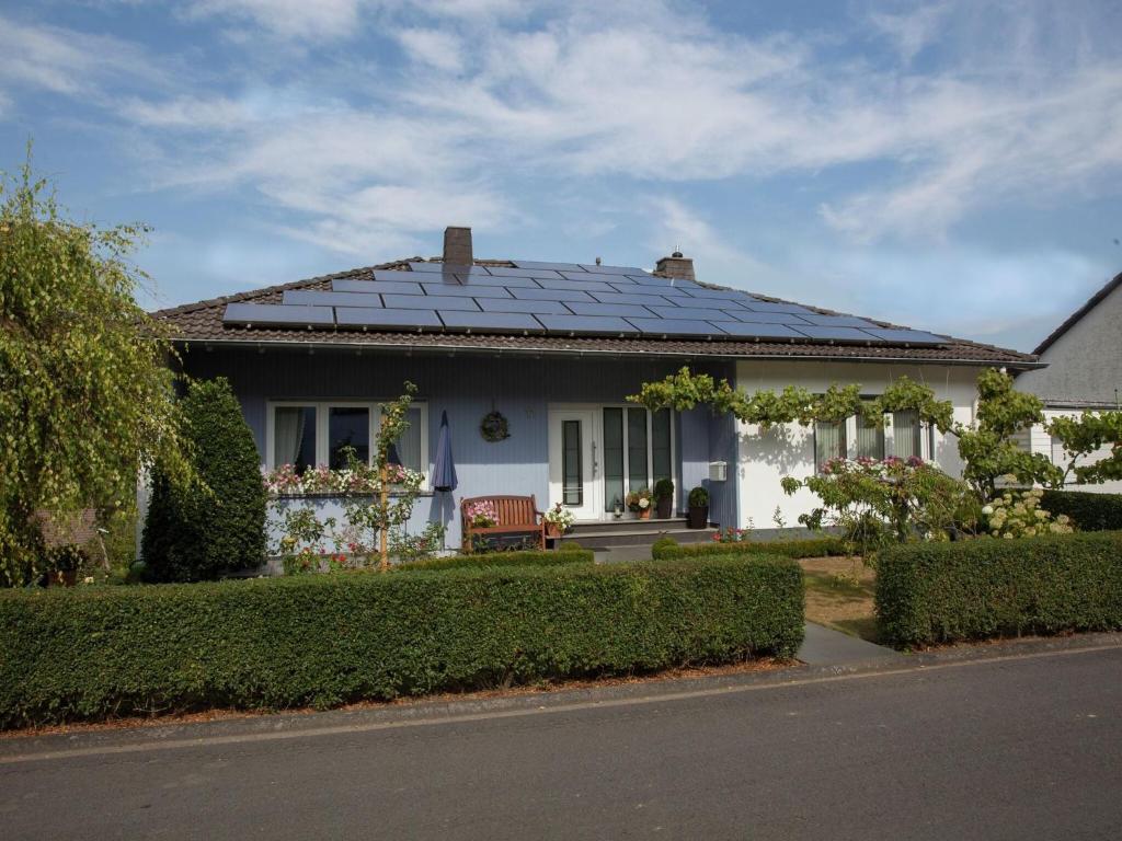 a white house with solar panels on the roof at Apartment in Niederehe near the forest in Üxheim